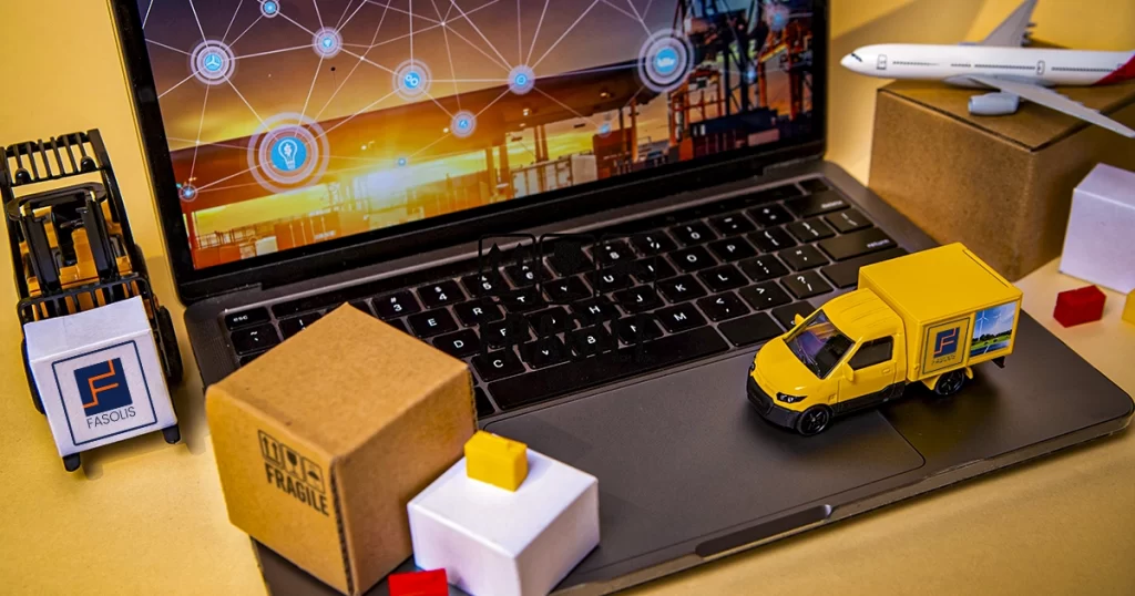 Imagem de um notebook, caixas e um caminhão ilustrando como a FASOLIS aplica a Logística Inteligente